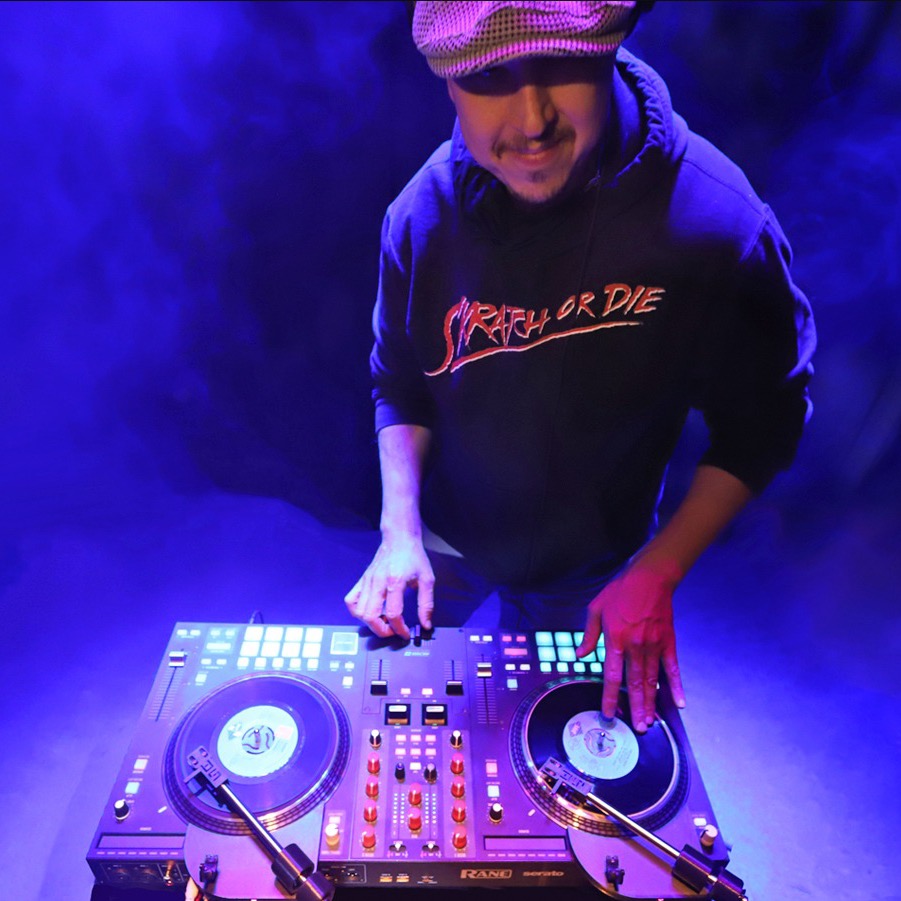 Sick James rocking the first set of Skratch Attach prototypes in purple stage light, 2021